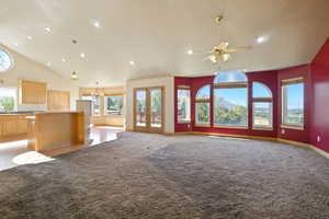 Unfurnished living room with plenty of natural light, carpet, recessed lighting, and high vaulted ceiling