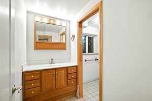 Bathroom featuring vanity, a textured ceiling, and light tile patterned floors