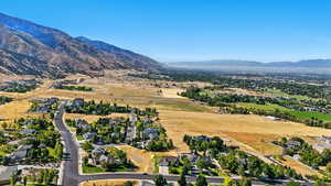 Aerial view of property and surrounding area with mountains and nearby suburban area