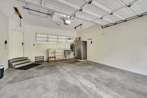 Garage with freestanding refrigerator and a garage door opener