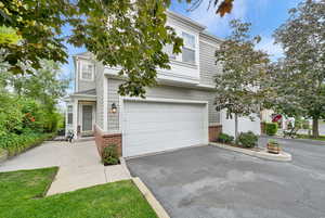 View of front of house with brick siding, asphalt driveway, and an attached garage