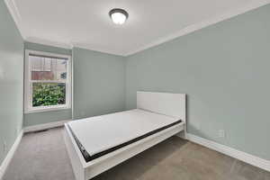 Unfurnished bedroom featuring light colored carpet and ornamental molding