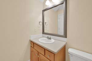 Half bathroom featuring vanity and toilet