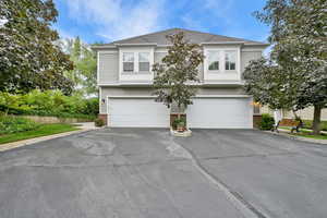 View of front of house featuring brick siding, asphalt driveway, and a garage