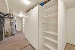 Finished basement featuring gas water heater and a textured ceiling