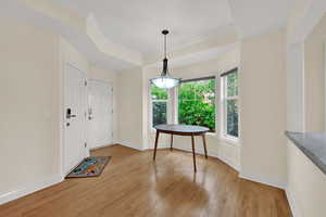 Dining space featuring light wood-style floors and a raised ceiling
