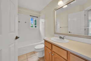 Bathroom with vanity, tub / shower combination, and light tile patterned flooring