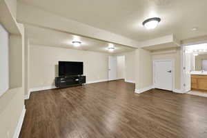 Unfurnished living room with a textured ceiling and dark wood-style floors