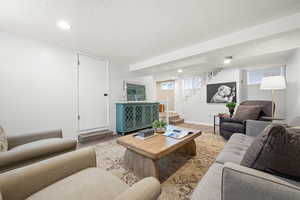 Living area featuring wood finished floors, stairway, a textured ceiling, and recessed lighting
