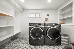 Laundry area with a textured ceiling, washer and clothes dryer, and recessed lighting