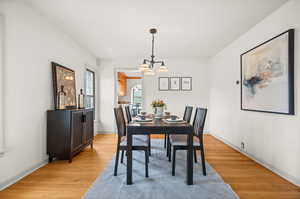 Dining area featuring light wood finished floors and a chandelier