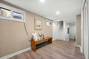 Basement featuring light wood-style flooring, stairway, recessed lighting, and healthy amount of natural light