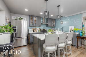 ADU Kitchen with a kitchen breakfast bar, decorative light fixtures, dark wood-style floors, and gray cabinetry