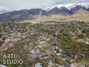 Aerial view of property and surrounding area with a mountain backdrop and nearby suburban area