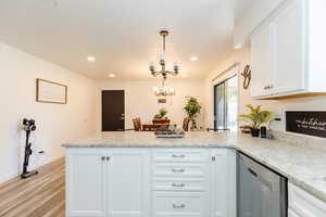 Kitchen featuring a peninsula, white cabinetry, dishwasher, recessed lighting, and hanging light fixtures