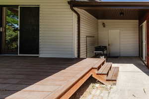 Wooden terrace featuring a patio