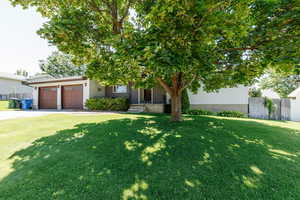 View of front facade featuring an attached garage, driveway, and a porch