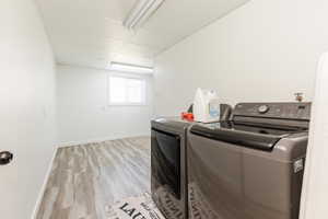 Washroom featuring light wood finished floors and separate washer and dryer