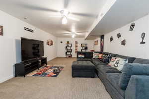Living area featuring light carpet and ceiling fan