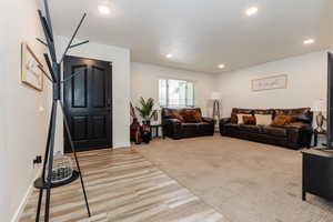 Living room with light wood finished floors and recessed lighting