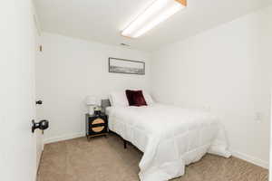 Bedroom featuring light colored carpet and baseboards