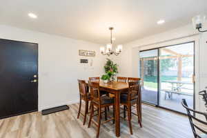 Dining room featuring recessed lighting, light wood-style floors, and a chandelier