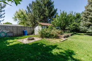 View of yard featuring a storage shed, an outdoor fire pit, and a patio area