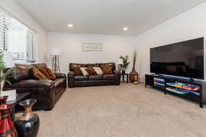 Living area featuring light carpet and recessed lighting