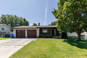 Ranch-style home featuring covered porch, a garage, driveway, board and batten siding, and roof with shingles