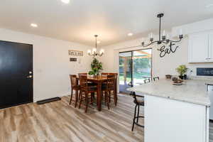 Dining space with a chandelier, light wood finished floors, and recessed lighting