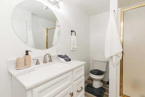 Full bath with vanity, a stall shower, and wood finished floors