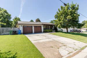 Single story home featuring a garage, concrete driveway, and a chimney