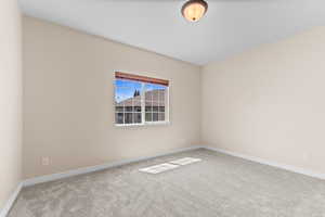 Carpeted spare room featuring baseboards