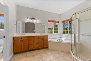 Bathroom with a shower stall, a garden tub, double vanity, light tile patterned flooring, and recessed lighting