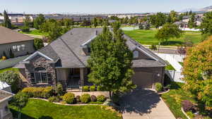 View of front of house with stone siding, concrete driveway, a residential view, a garage, and stucco siding