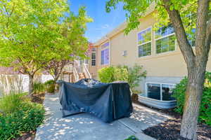 View of patio with a grill and stairs