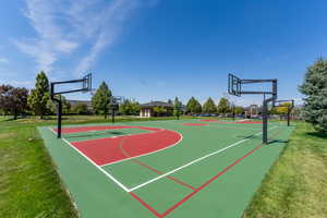 View of basketball court with community basketball court and a yard