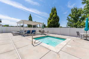 View of swimming pool with a patio, a pool, a fenced backyard, and a pergola