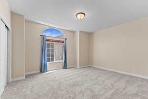 Unfurnished bedroom featuring light carpet and a closet