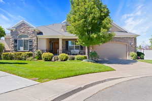 View of front of house with concrete driveway, stone siding, and a garage