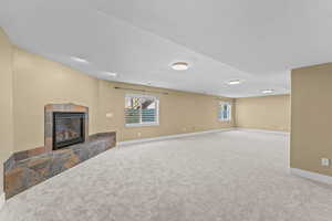 Unfurnished living room with a tile fireplace, carpet flooring, and a textured ceiling