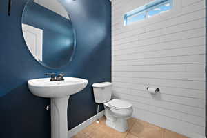 Half bathroom featuring toilet and tile patterned floors