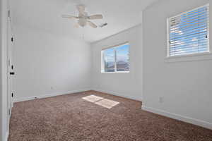 Carpeted empty room featuring baseboards and ceiling fan