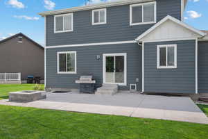 Back of house with a patio, a lawn, a fire pit, and board and batten siding