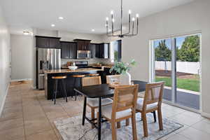 Dining space with a chandelier, light tile patterned floors, and recessed lighting