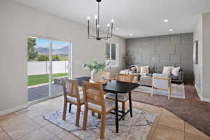 Dining area with a chandelier, recessed lighting, a mountain view, light tile patterned flooring, and light carpet