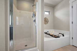 Full bath with a shower stall, a bath, and tile patterned floors