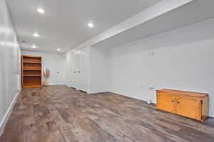 Finished below grade area featuring recessed lighting and dark wood-style flooring