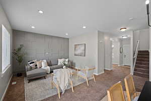 Carpeted living room featuring stairway and recessed lighting