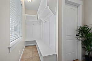 Mudroom featuring light tile patterned floors and baseboards